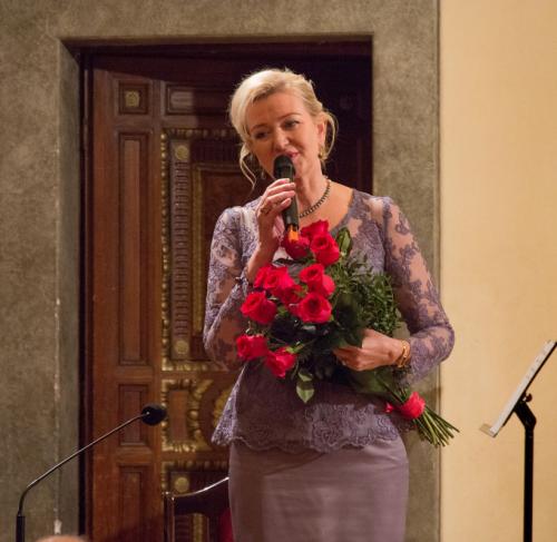 Elżbieta Gładysz obdarowana kwiatami wita publiczność.